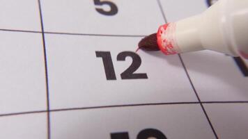 evidenziazione Data numero 12 su un' calendario, con un' grassetto rosso attraversare marchio sottolineando un importante promemoria o in programma evento. video
