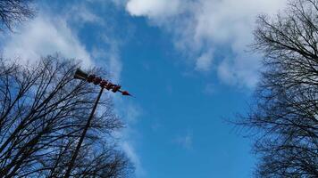 n exhilarating low-angle shot focusing on the The Rocket themed extreme pendulum ride as it reaches its apex, emphasizing the height and speed. Passengers are strapped into the multiple red seats video