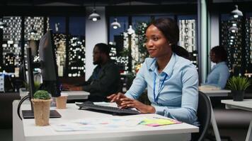 svart ung analytiker fokuserade på den företag utveckling med digital verktyg, recension analys och prestanda metrik på arbetsstation. personal planera lösningar och inriktning mål. kamera a. video