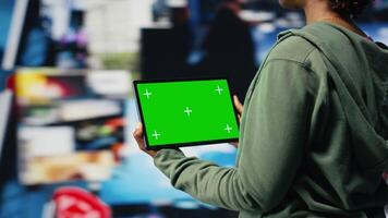 Green screen tablet used by person to look at internet channels, isolated over digital backdrop. Woman enjoys unlimited metaverse content with mockup device, 360 degrees rotation, camera B video