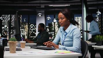 svart kvinna Arbetar på forska och dokumentera rapporter efter timmar, data uppdateringar och företag företag, efter timmar arbete i en mörk kontor. finansiera mål och projekt utveckling. kamera a. video