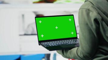 Green screen mockup laptop used by person to get access to recommendations delivered instantly. User in digital era enabling unlimited streaming looking at clips on chroma key notebook video