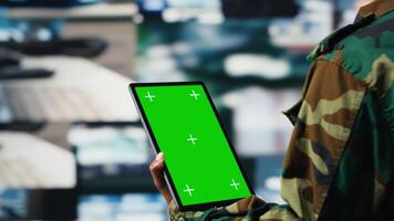 Isolated screen tablet app used by soldier in war room to operate CCTV gear. Army operator using chroma key device to deploy electronic warfare tools used to disrupt enemy communications, camera B video