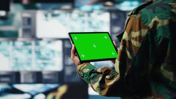 Isolated screen mockup tablet warning system used by military operator to monitor incoming enemy aerial attacks. Army agent maintains air space superiority with radar on chroma key device, camera B video