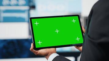 grön skärm läsplatta Begagnade förbi team ledare till jämföra företag metrik innan framställning beslut. professionell analyserar nyckel prestanda indikatorer använder sig av attrapp enhet, stänga upp video