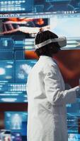 vertikal forskare granskning medicinsk skannar använder sig av virtuell verklighet teknik, 360 grader rotation. kvinna i främre av digital hälsa instrumentpaneler bakgrund analyserar mänsklig anatomi med vr glasögon redskap, kamera en video