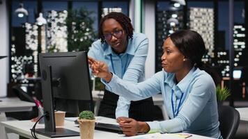 Team of two female associates monitoring data insights at the workspace, utilizing analytics to plan forecast for detailed performance metrics and statements. Goal setting after hours. Camera B. video