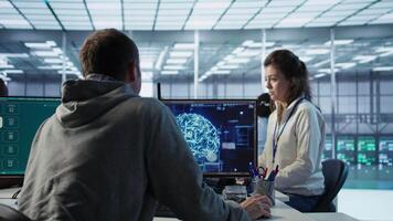 ingenjör i server rum småpratar med kollega medan framställning ai alstrande videoklipp programvara. den anställd och medarbetare talande medan byggnad artificiell intelligens diffusion modell app, kamera b video