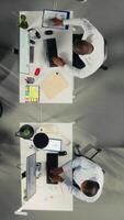 vertical topo baixa Visão do profissional empregados trabalhando juntos dentro escritório. diverso trabalhos equipe colabora em projeto planejamento, analytics e relatório escrevendo para corporativo desenvolvimento. Câmera uma. video