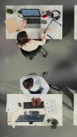vertikal topp ner se zoom i av olika personal i kontor arbetssätt på prognoser. professionell personal recension visuell data och diagram till förbättra effektiv förvaltning och företag mål. kamera a. video