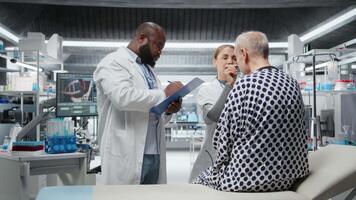 verschillend wetenschappers het uitvoeren van observatie en examen van een geduldig in een Onderzoek laboratorium, testen een nieuw behandeling en analyseren dosering Effecten. aan het studeren risico's en resultaten voor voortgang. camera a. video