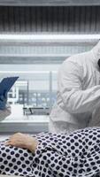 vertikal sjukvård professionell i hazmat kostym utför diagnostik på en patient smittad med farlig virus, studerar immunitet och vaccination svar i en säkra bioinneslutning miljö. kamera a. video
