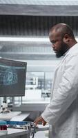 vertikal svart läkare använder sig av artificiell intelligens till observera effekt under ny läkemedel testa, samlar farmakologi data med neuralt nät systemet. biomedicin upptäckt och innovation. kamera a. video