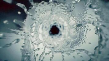 dinâmico lento movimento do uma rodopiando Claro água vórtice criando uma líquido túnel efeito. uma fresco e puro aqua respingo fundo. video