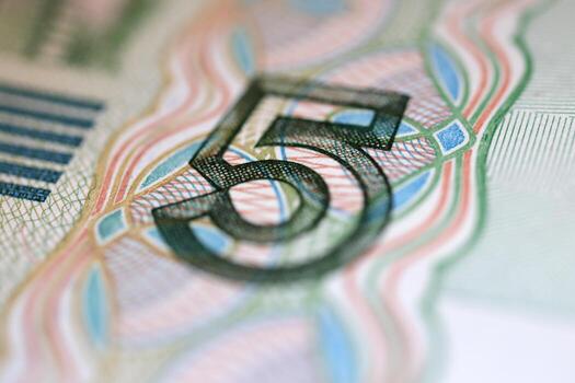 Close-up of a five-dollar bill showing intricate details of the number 5 photo