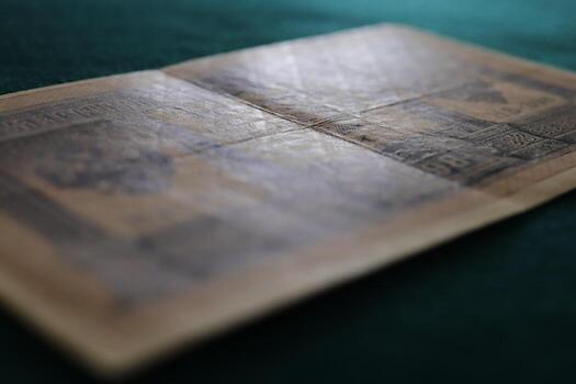 An old, worn banknote displayed on a green surface, showing intricate designs and faded colors photo