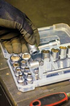 Mechanic Hand Selecting Socket Wrench from Tool Set in Workshop photo