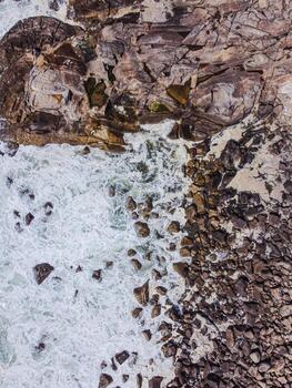 An abstract top down view of sea foam swirling in rock formations The Abstract Art of a Geological Wonder photo