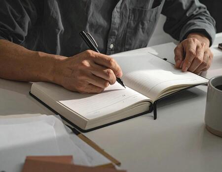 Writing in Notebook Man's Hands with Pen on Open Journal, diary photo