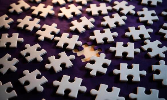 Light gray jigsaw puzzle pieces scattered on a deep purple background with a missing piece photo