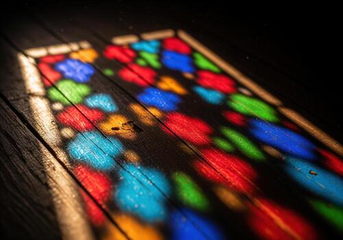 Vibrant and colorful stained glass light patterns on a dark wooden floor photo
