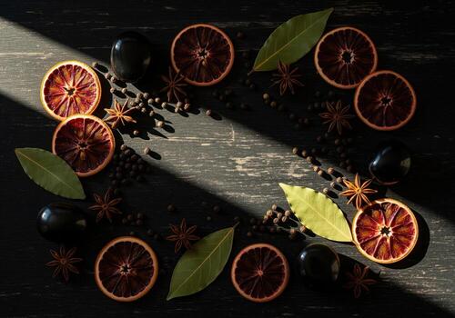 Aromatic spices and dried citrus botanicals artfully arranged on a dark rustic wooden surface photo
