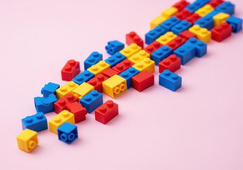 vistoso el plastico edificio bloques arreglado en un dinámica modelo en un rosado superficie foto