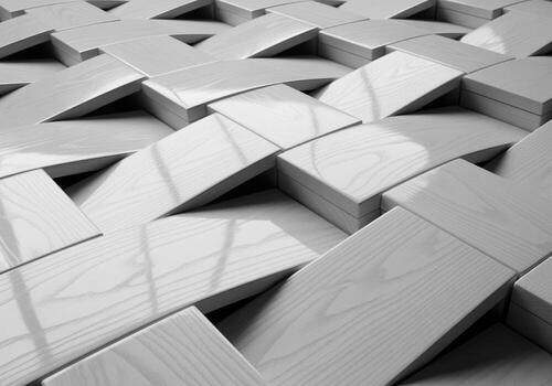 Glossy bleached white ash wood tiles arranged in a complex geometric basketweave pattern photo