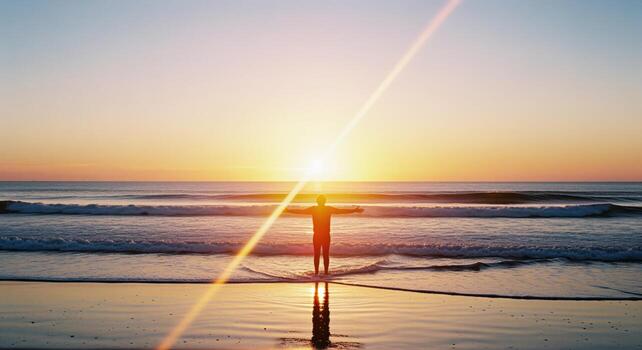 Man with outstretched arms on a serene beach at sunrise, reflecting hope and new beginnings photo