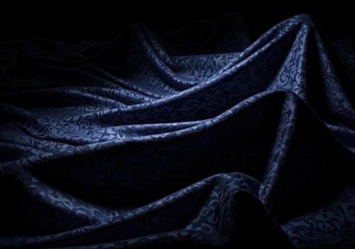 Dramatic folds of luxurious midnight blue brocade fabric with subtle ornate patterns and rich texture photo