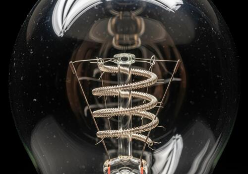 Close up of a specialized filament inside a light bulb, highlighting internal mechanics and material science photo