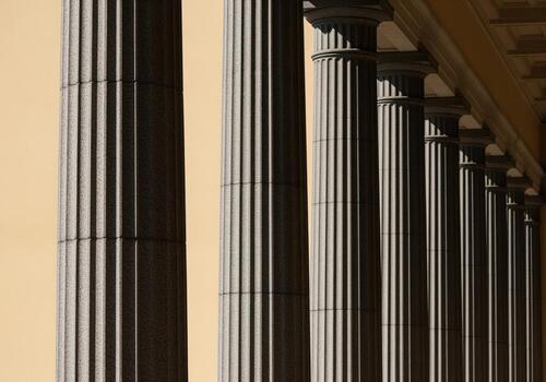 Long row of classical architectural columns with strong shadows and repetitive pattern photo