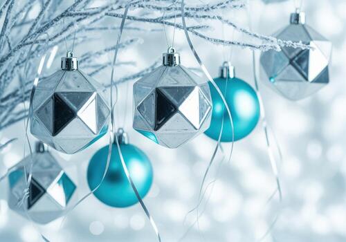 Elegant silver and teal christmas ornaments hanging from frosted branches with bokeh lights photo
