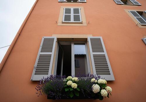 europeo edificio fachada con abierto ventana, blanco persianas, y vistoso flor caja foto