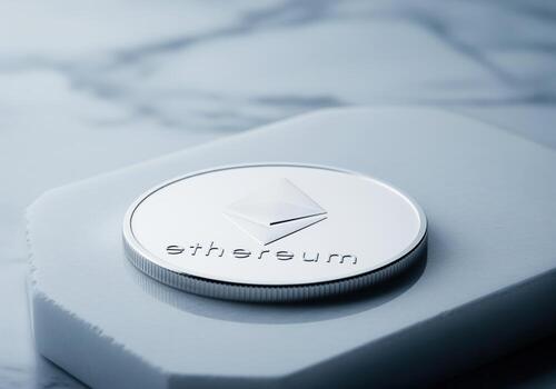Shiny silver ethereum cryptocurrency coin resting on a sleek white surface photo