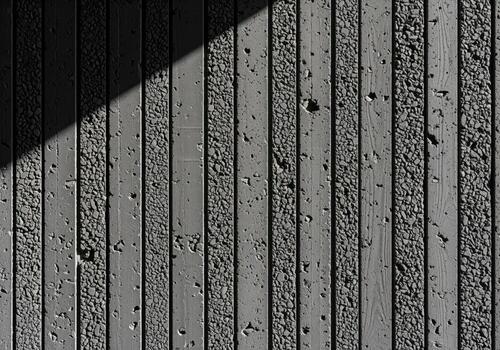 Modern dark grey concrete facade with vertical aggregate and smooth textured panels photo
