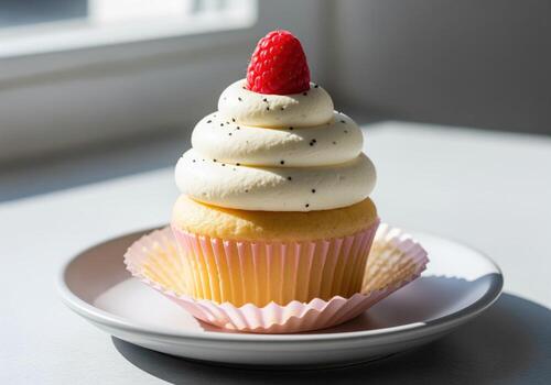 Sweet vanilla cupcake with elegant whipped cream and a single fresh red raspberry photo