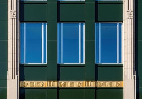 Sleek art deco building facade with three rectangular windows and gold details photo