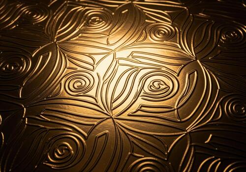 Luxurious metallic gold foil texture with embossed art deco swirling pattern photo