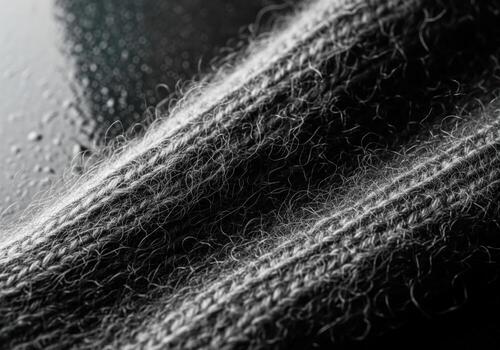 High contrast macro detail of fuzzy dark gray wool knitted fabric texture. photo