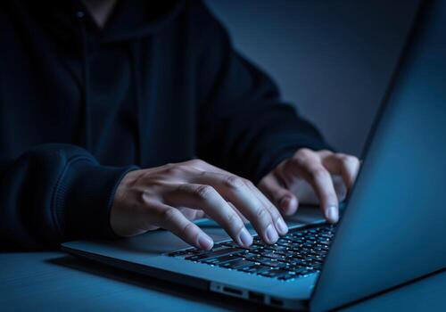 hacker manos rápidamente mecanografía en ordenador portátil teclado en oscuro, intenso ciber escena foto