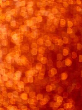 Abstract orange bokeh background with hexagonal light reflections photo