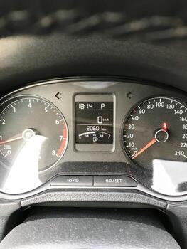 A black car dashboard with a red and white speedometer photo