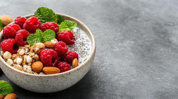 Raspberries, almonds and chia seeds in a bowl on a dark background photo