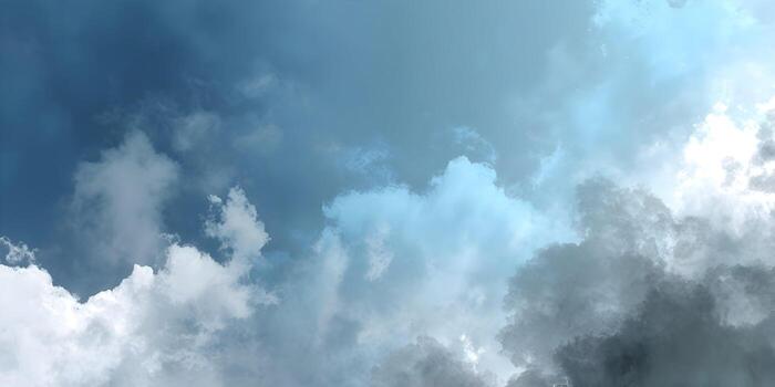 A serene blue sky is filled with a mix of fluffy white and moody dark clouds creating an atmospheric backdrop photo