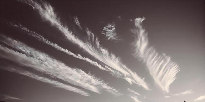 Delgado cirro nubes racha a través de un sepia cielo creando un etéreo y resumen modelo foto