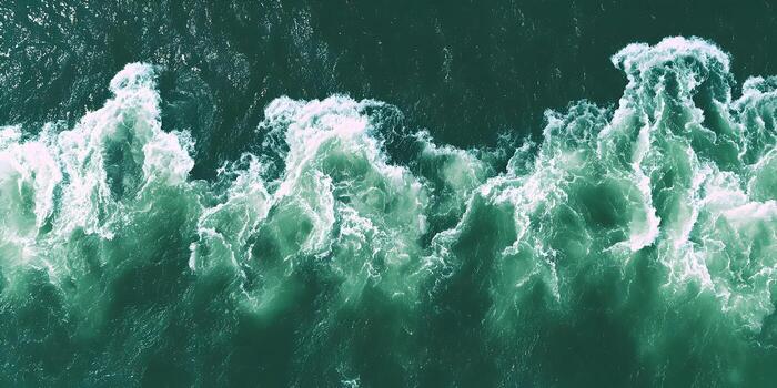 Aerial view of mesmerizing green ocean waves with white foam creating a powerful natural pattern photo