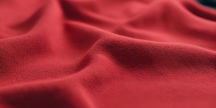 A detailed closeup shot of rich red textured fabric showing soft folds and creases creating an abstract background photo