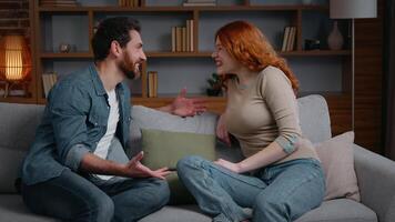 kaukasisch glücklich lächelnd Paar reden auf Couch beim Zuhause emotional Mann Ehefrau kommunizieren Mann Teilen gut Nachrichten mit aufgeregt Frau im Leben Zimmer freunde Ehepartner Familie Freundin Freund Lachen video