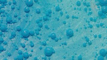 parte superior ver fantástico estructura de vistoso petróleo pintar y tinta burbujas caótico movimiento. resumen azul pintar. movimiento en líquido. agua superficie multicolor textura antecedentes. macro. patrón, diseño video